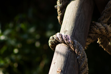 Close-up of Thick Rope Twisted Around a Wooden Post in Sunlight