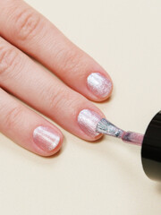 woman paints her nails with nail polish and applies nail polish with a brush. nail and hand skin care, nail service salon, manicure and pedicure.