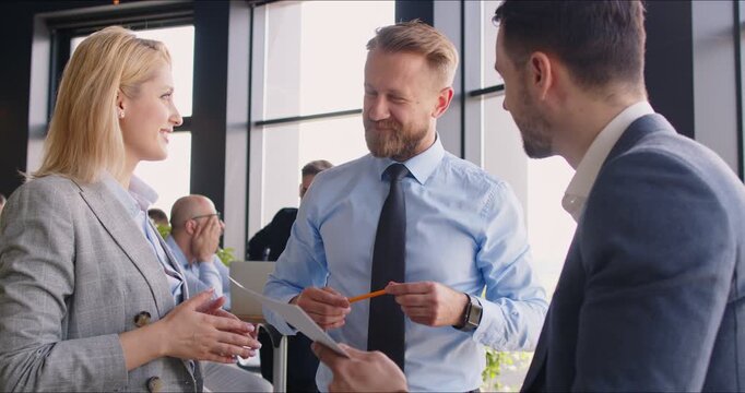 Positive coworkers talking and discussing together during a productive meeting in the office. People collaboration, teamwork and effective communication contribute to a work environment.
