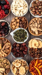 Overhead shot of various dried herbs and nuts in small bowls arranged on a wood surface