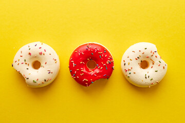 Overhead view of various donuts with confetti arranged on colored background