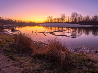 amazing frosty sunrise over the river with forest on background 
