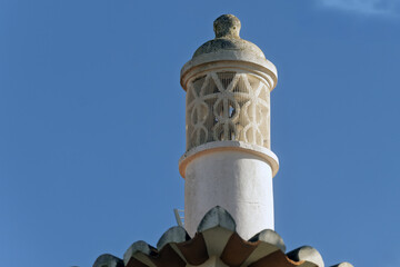 Ornate chimney with decorative top structure Terracotta roof tiles below in Portimao, algarve, Portugal