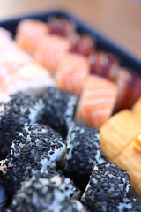 A colorful assortment of sushi is artfully displayed on a platter, showcasing different fish and rolls at a restaurant during lunch time.