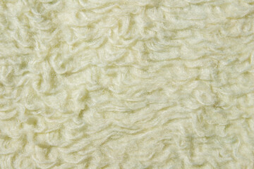 Soft cream fabric textile background with fluffy fiber texture, closeup of woven material surface. Abstract upholstery cloth pattern for design, furnishing, and fashion detail