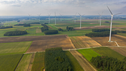 Aerial View of Wind Turbines Over Countryside Farmland and Forests