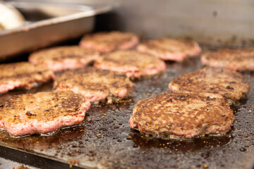 hamburgers lined up on a griddle at fast food restaurant