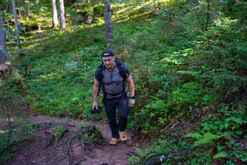 Hiker with camera in forest trail