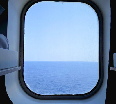 ship's cabin porthole with sea view during summer navigation
