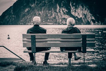 Old couple sitting on a bench on Lake Garda