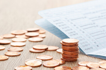Pile of coins on wooden table with open bank passbook, concept of savings, finance, investment, accounting, and money management.