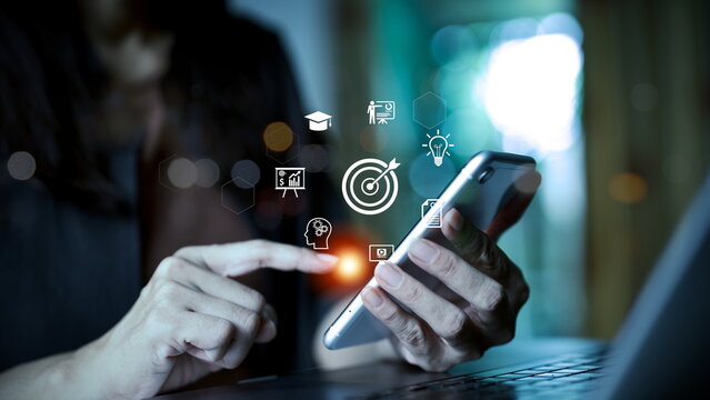 Businesswoman using smartphone with digital marketing icons, showing business target, strategy, innovation, data analytics, education, idea, and growth concept for online communication and success.