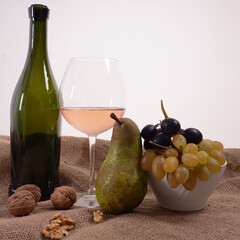 Frutta e bicchiere di vino con bottiglia. pera, uva, e noci