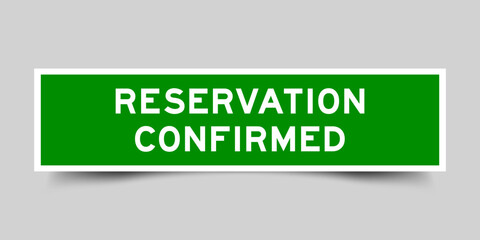 Green color square shape sticker label with word reservation confirmed on gray background