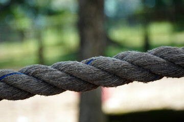 Fototapeta premium A close-up view of a strong, thick rope with a visible braided texture. The image represents strength, connection, and a rustic, natural feel.