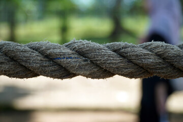 A close-up view of a strong, thick rope with a visible braided texture. The image represents...