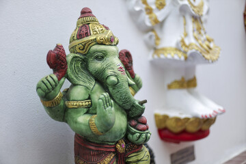 Vibrant green Ganesha statue revered Hindu deity embodies spiritual wisdom prosperity. Crafted ceramic intricate detail showcases traditional artistry. Serene expression conveys divine blessing