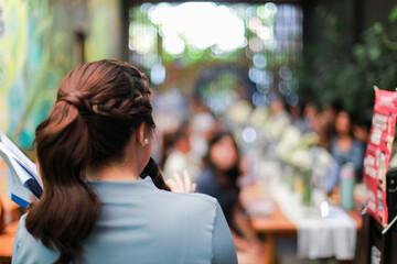 back view of a female speaker in front of an audience, informal event