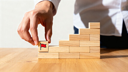 Hand placing flag block on wooden steps