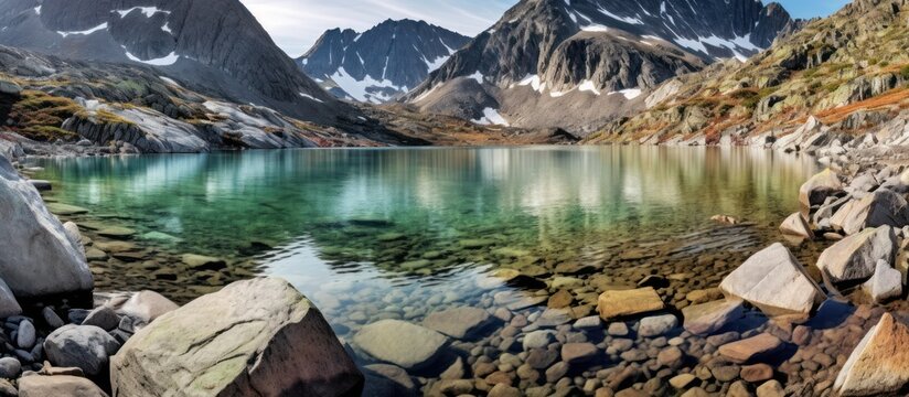 mountainous landscape,rocky shoreline,crystal clear lake,snow-capped peaks,rugged terrain,peaceful reflection,natural beauty,serene atmosphere,dramatic skyline,outdoor scenery
 - Powered by Adobe
