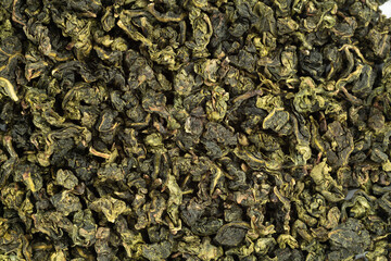 Te Guan Yin tea leaves close up as a background. Top view.
