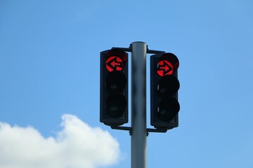 Two red turn signals next to each other, one with a red arrow pointing right and one with a red arrow pointing left