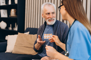 Senior man discussing medication with female nurse
