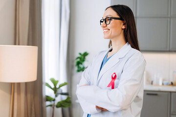Female doctor wearing pink ribbon for breast cancer awareness