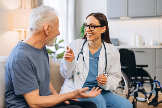 Doctor visiting senior man at home discussing healthcare - Powered by Adobe