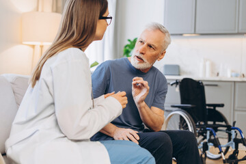 Fototapeta premium Elder patient discussing health issues with doctor at home
