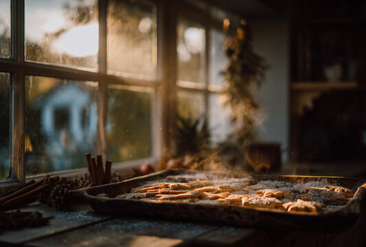 a rustic tray filled with freshly baked gingerbread cookies. The cookies are shaped in festive designs, such as stars and snowflakes, with a light dusting of powdered sugar on top.