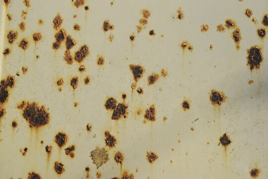 Parede branca met&aacute;lica com pequenas manchas marrons de ferrugem, textura de parede enferrujada