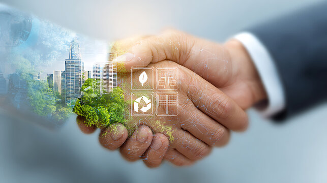 Double exposure of a handshake with a cityscape and green icons representing sustainability business