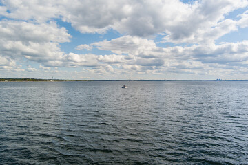 Aerial drone view of a small motorboat sailing in Tallinn Bay, Estonia, under a beautiful cloudy sky.