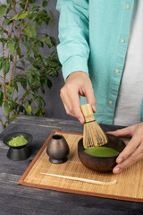 Man making matcha tea ceremony in a bamboo bowl, closeup
