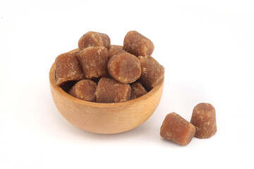 Organic jaggery in wooden bowl on white background