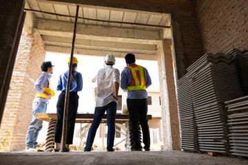 Professional engineering team working : Unity and teamwork. construction worker Architects and contractor working together at building under construction site. Engineering in safety harthat helmet