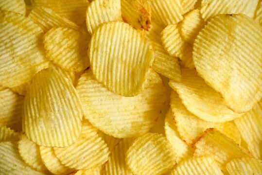 Pile of Crispy, Golden Ruffled Potato Chips Texture