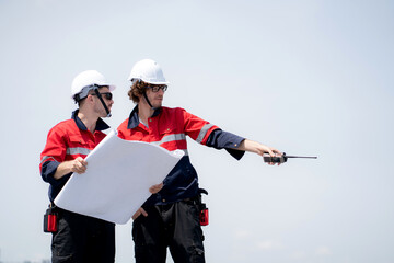 Two engineer checking solar energy system looking blueprint together for planning installation solar panel, renewable energy and sustainable technology, clean electricity, industry and solar cell.