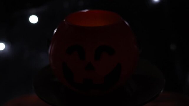 Un primer plano de una calabaza de halloween con un fondo negro con luces desenfocadas. Feliz halloween