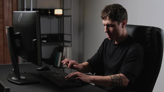 Stressed man in home office angrily hitting computer keyboard remote work burnout frustration