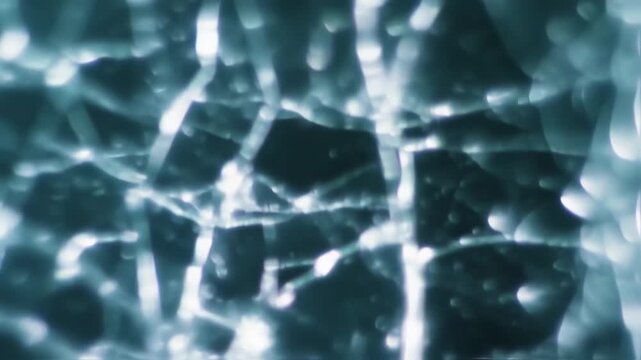 Abstract Glass Surface with Cracks and Reflections in Blue Tones.