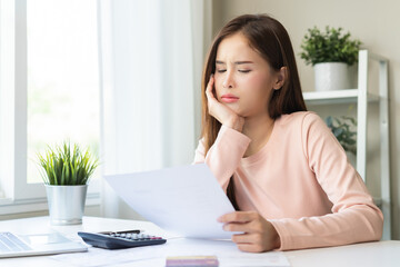 Business financial concept, stressed asian young woman hand checking list statement of credit card for calculate accounting expense, tax for payment on due deadline, trying to find money to pay debt.