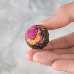 Green tea ball with flowers in hand.
