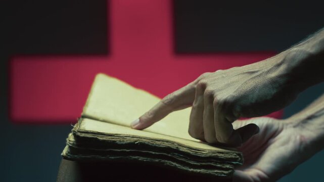 Person's hand reads an empty book on Halloween night