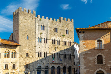 Massa Marittima, Palazzo del Podesta with crenellated walls under blue sky