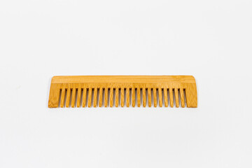 A handcrafted wooden comb with smooth finish and natural grain isolated - on white background. Designed for gentle hair grooming. 