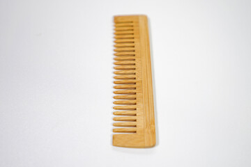 A handcrafted wooden comb with smooth finish and natural grain isolated - on white background. Designed for gentle hair grooming. 