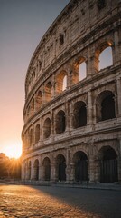 Naklejka premium Ancient roman colosseum architecture illuminated by warm sunlight at sunset