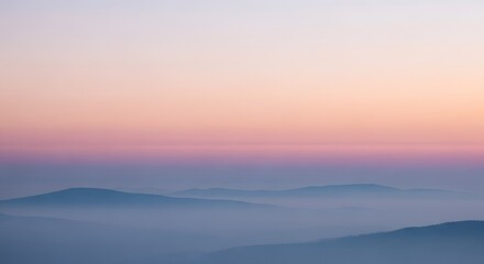 Misty mountain peaks at sunrise with soft pastel sky